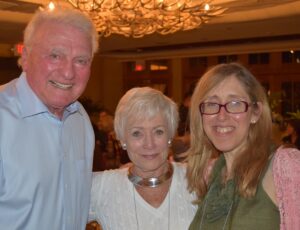 Three smiling people facing camera.